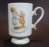 1973 Holly Hobbie Genuine Porcelain WWA "Love is the little things you do" Girls Smelling Flowers Pedestal Mug Cup - Treasure Valley Antiques & Collectibles