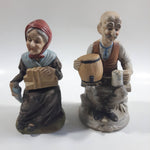 Old Man Sitting With Keg Barrel and Beer Stein and Old Woman Sitting with Umbrella and Packages Porcelain Figurines Set of 2