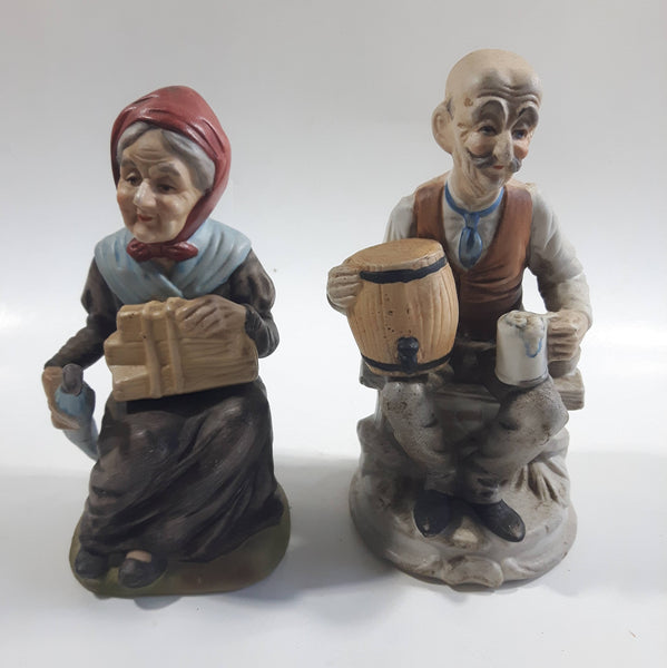 Old Man Sitting With Keg Barrel and Beer Stein and Old Woman Sitting with Umbrella and Packages Porcelain Figurines Set of 2