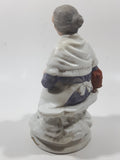 Old Woman Sitting with Basket of Bread Holding a Pear and Banana 6 1/2" Tall Porcelain Figurine