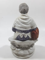 Old Woman Sitting with Basket of Bread Holding a Pear and Banana 6 1/2" Tall Porcelain Figurine