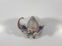 Old Woman Sitting with Basket of Bread Holding a Pear and Banana 6 1/2" Tall Porcelain Figurine