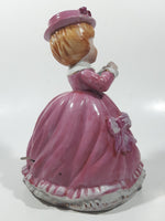 Vintage Girl in Pink Dress with Bows Wearing a Hat Holding Pen and Paper 7" Ceramic Wind Up Musical Figurine