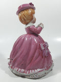 Vintage Girl in Pink Dress with Bows Wearing a Hat Holding Pen and Paper 7" Ceramic Wind Up Musical Figurine