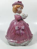 Vintage Girl in Pink Dress with Bows Wearing a Hat Holding Pen and Paper 7" Ceramic Wind Up Musical Figurine