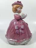 Vintage Girl in Pink Dress with Bows Wearing a Hat Holding Pen and Paper 7" Ceramic Wind Up Musical Figurine