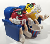 1999 M & M's Red And Yellow Character Sitting In Movie Theater Chairs Eating Popcorn Wearing 3D Glasses Plastic Candy Dispenser Machine