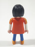 1992 Geobra Playmobil Woman with Black Hair Orange and Yellow Striped Sweater Over White Top and Blue Jean Pants 3" Tall Toy Figure
