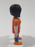 1992 Geobra Playmobil Woman with Black Hair Orange and Yellow Striped Sweater Over White Top and Blue Jean Pants 3" Tall Toy Figure